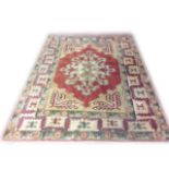 A TURKISH SIVAS WOLLEN RUG Cream ground with red central lozenge and stylized gul motifs. (approx