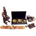 AN EARLY 20TH CENTURY EBONISED BRASS MICROSCOPE Marked 'C. Baker', together with a cased set of