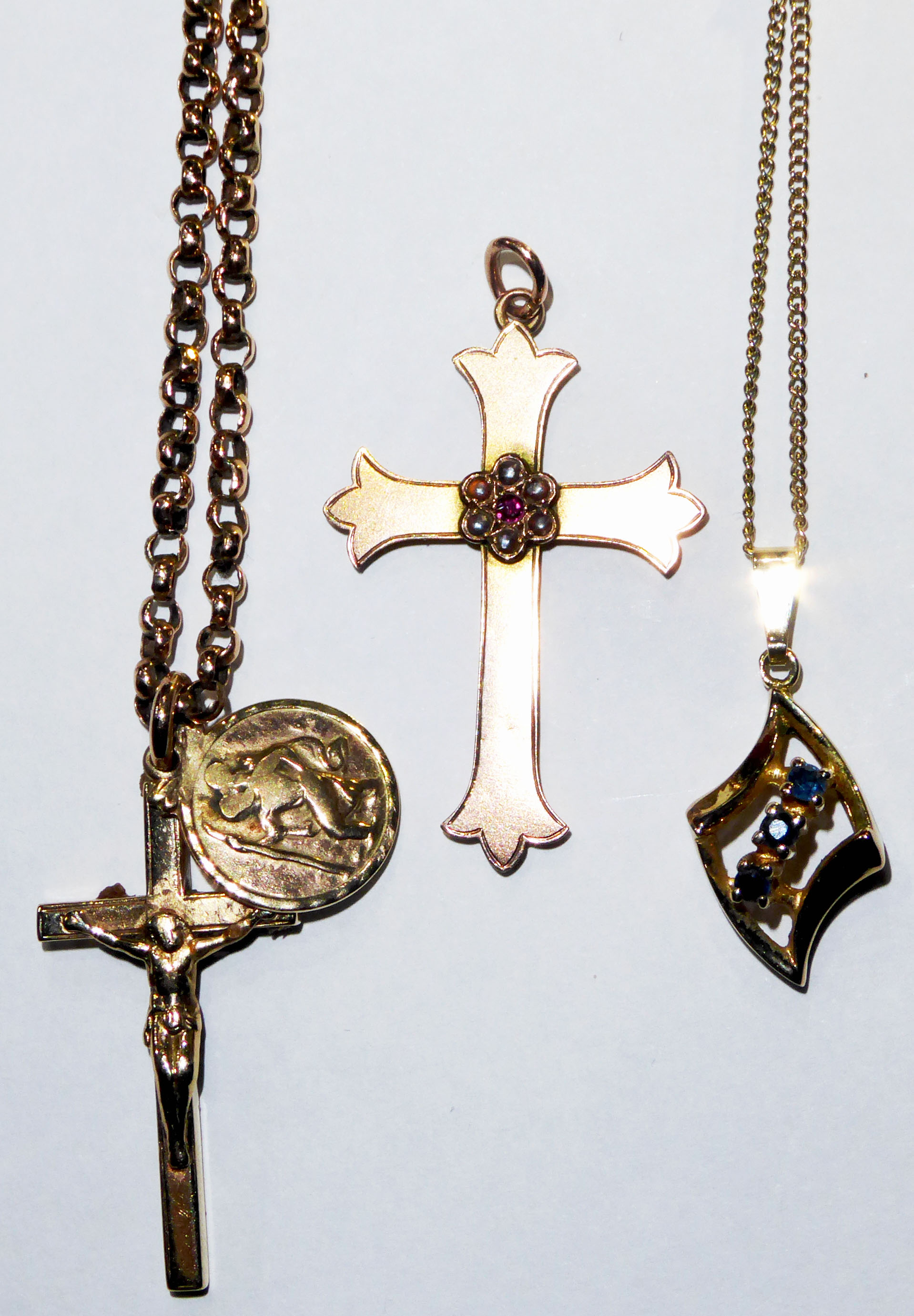 A COLLECTION OF VINTAGE 9CT GOLD PENDANTS Two crucifixes, one set with a single ruby and seed