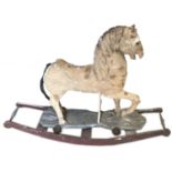 A VICTORIAN DISTRESSED PAINTED CARVED WOOD ROCKING HORSE Supported on later stand.