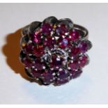 A VINTAGE 18CT WHITE GOLD AND RUBY CLUSTER RING Having round cut rubies set in a spiral shape