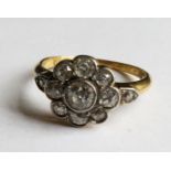 AN 18CT GOLD AND DIAMOND DAISY CLUSTER RING With an arrangement of eleven round cut diamonds (size