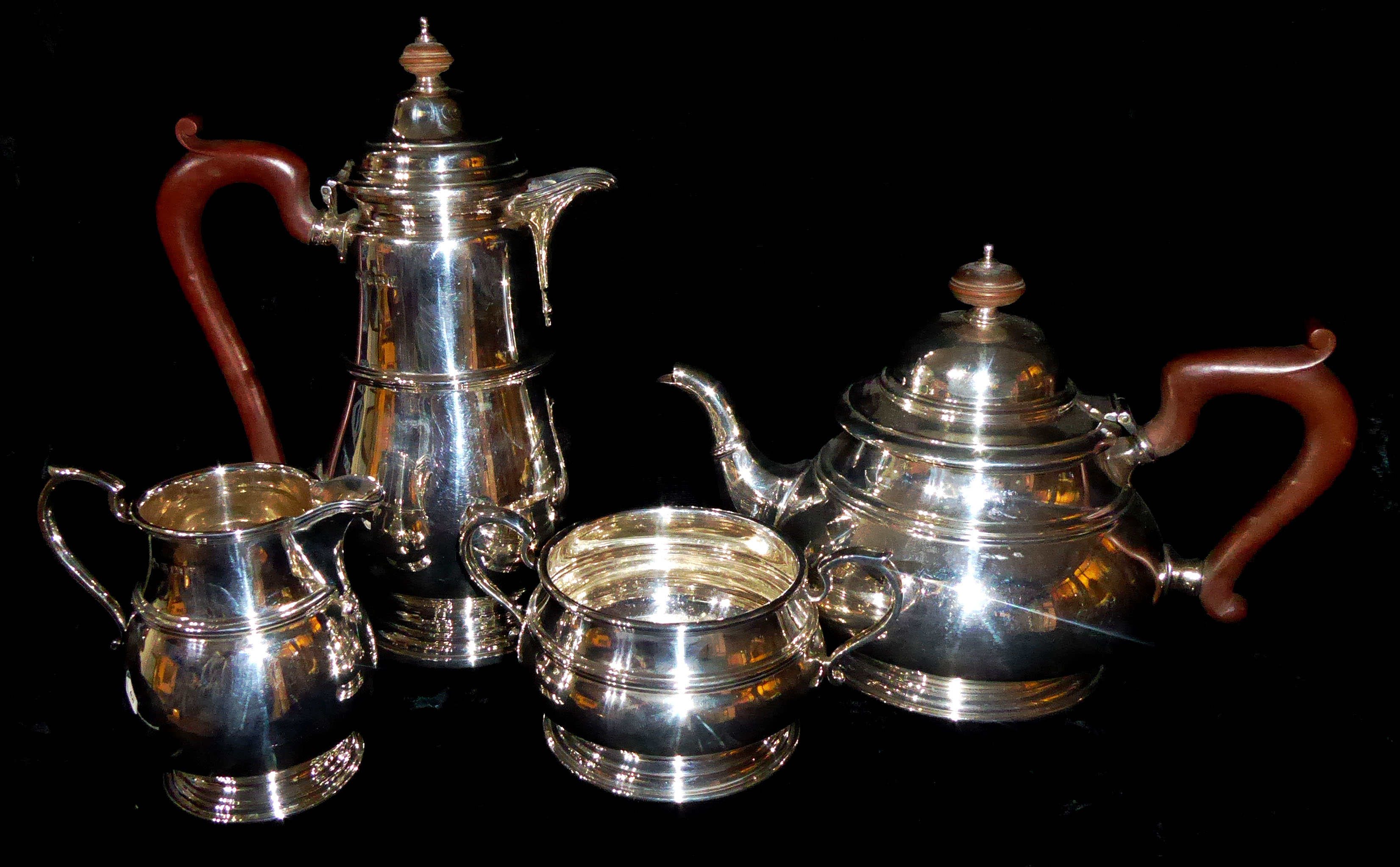 A VINTAGE GEORGIAN STYLE FOUR PIECE SILVER TEA SERVICE Comprising a teapot, hot water jug, sugar