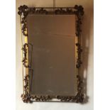 A 20TH CENTURY GILT AND PLANISHED BRONZE FRAMED MIRROR Cast with leaves and berries. (64cm x 91cm)