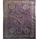 A PERSIAN SHIRAZ WOOLEN RUG Hand woven with a lozenge form central field on purple ground. (approx