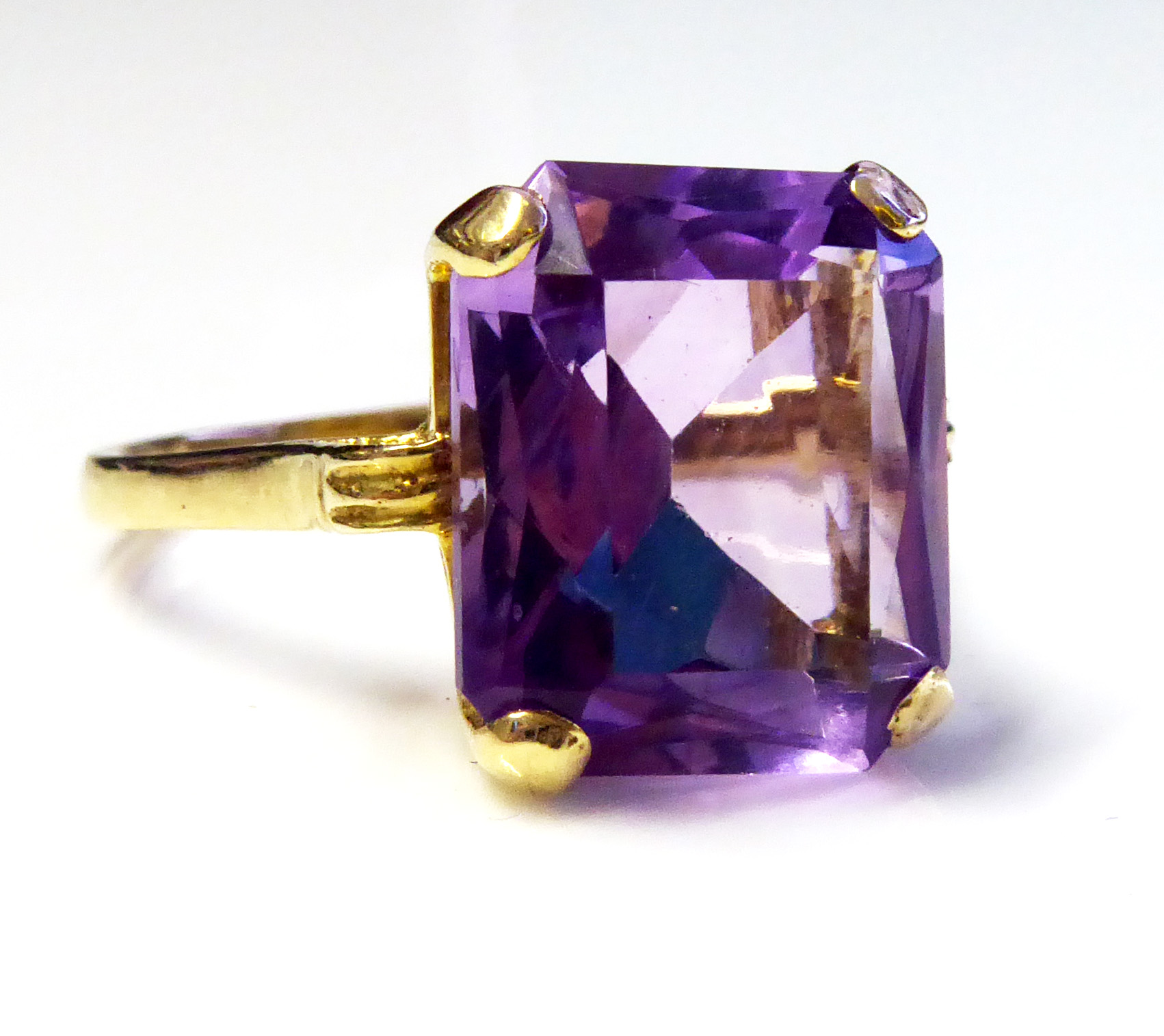 A VINTAGE 9CT GOLD AMETHYST RING Having a baguette cut stone, claw set on a plain good shank (size