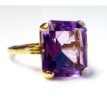 A VINTAGE 9CT GOLD AMETHYST RING Having a baguette cut stone, claw set on a plain good shank (size