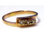 A VINTAGE 9CT GOLD AND DIAMOND THREE STONE RING Having three round cut stones, held in a half