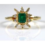 A 14CT GOLD, DIAMOND AND EMERALD DAISY CLUSTER RING Set with a single baguette cut emerald