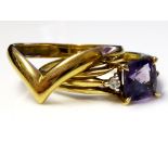 A VINTAGE 9CT GOLD, AMETHYST AND DIAMOND RING Having a single amethyst flanked with diamonds, on a