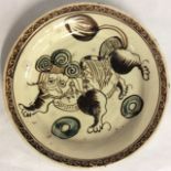 A CHINESE YUAN DYNASTY BROWN CIZHOU GLAZE POTTERY PLATE Hand painted with a stylized Dog of Fo. (