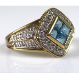 A 9CT GOLD, DIAMOND AND AQUAMARINE RING The lozenge shaped facet having four cushion cut