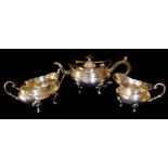 AN EDWARDIAN SILVER TEA SERVICE Comprising a teapot with carved wooden handles, finials and