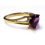 A VINTAGE 9CT GOLD AND AMETHYST RING Having a single heart form stone, held in a plain good shank (