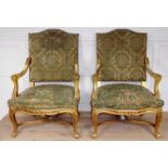 A PAIR OF CONTINENTAL OPEN ARMCHAIRS With distressed tapestry upholstery, carved cream painted