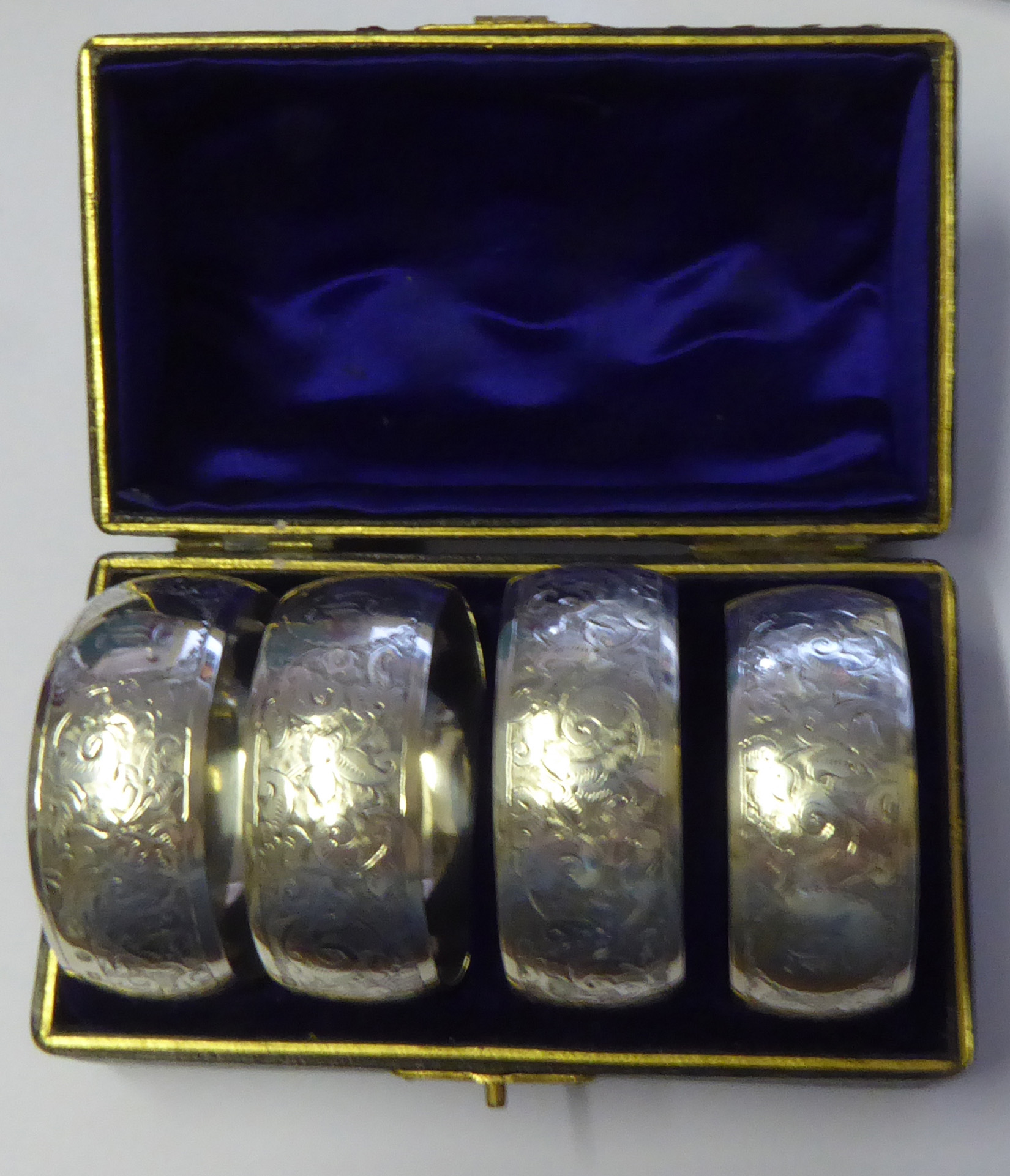 A CASED SET OF FOUR EARLY 20TH CENTURY SERVIETTE RINGS Having engraved decoration hallmarked