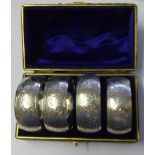 A CASED SET OF FOUR EARLY 20TH CENTURY SERVIETTE RINGS Having engraved decoration hallmarked