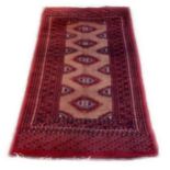 THREE VINTAGE BOKHARA RUGS Red fields with central geometric motifs. (approx 56cm x 158 cm) (80cm