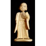 A CHINESE IVORY OKIMINO FIGURE Carved as an elder holding a peach, constructed from three