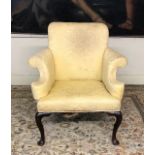 AN 18TH CENTURY (POSSIBLY IRISH) WALNUT ARMCHAIR Upholstered in a yellow fabric and with scroll