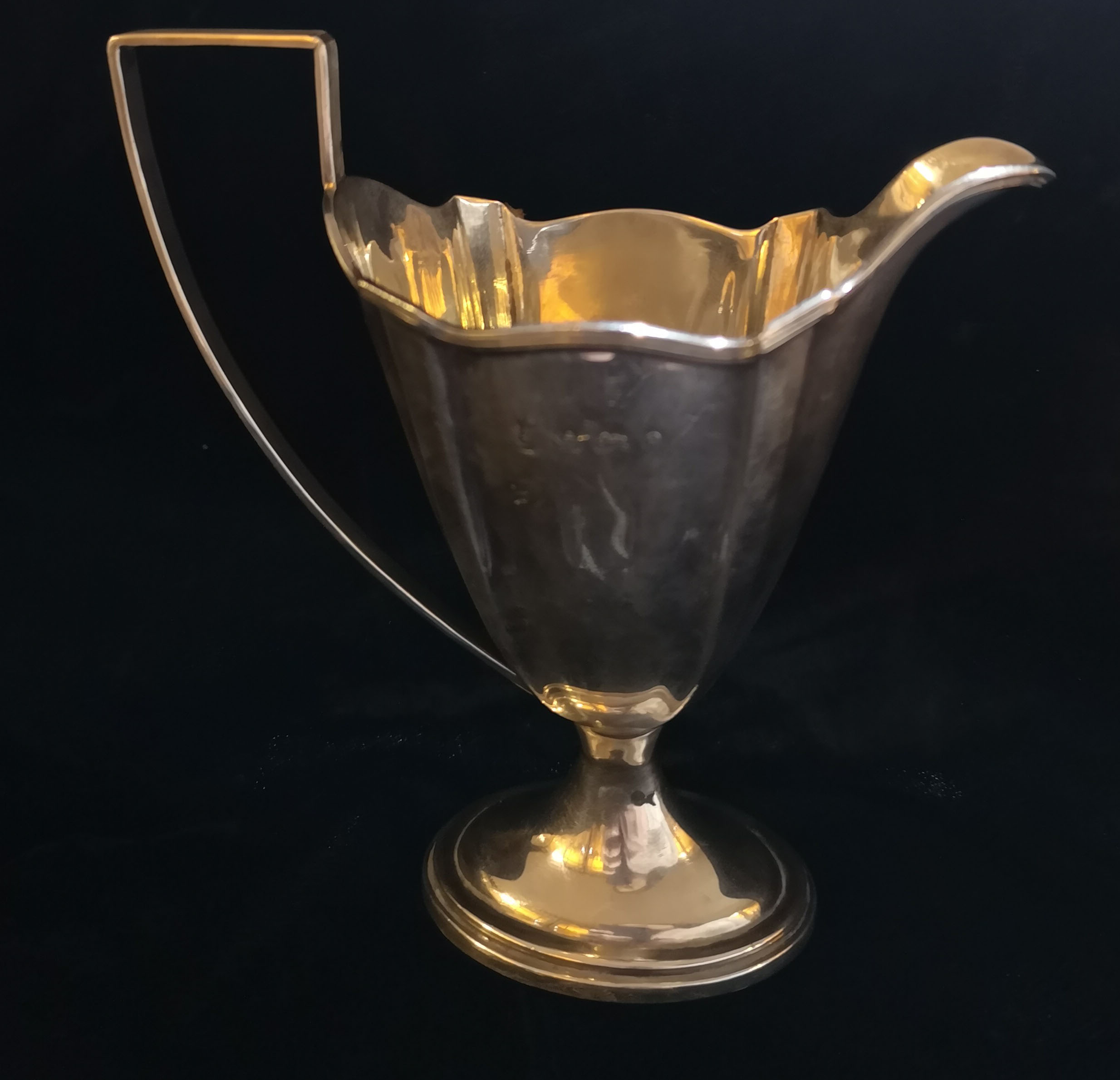 AN EDWARDIAN SILVER HELMET JUG With ribbed edge and handle, raised on a socle base. (h 13.5cm)