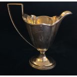 AN EDWARDIAN SILVER HELMET JUG With ribbed edge and handle, raised on a socle base. (h 13.5cm)