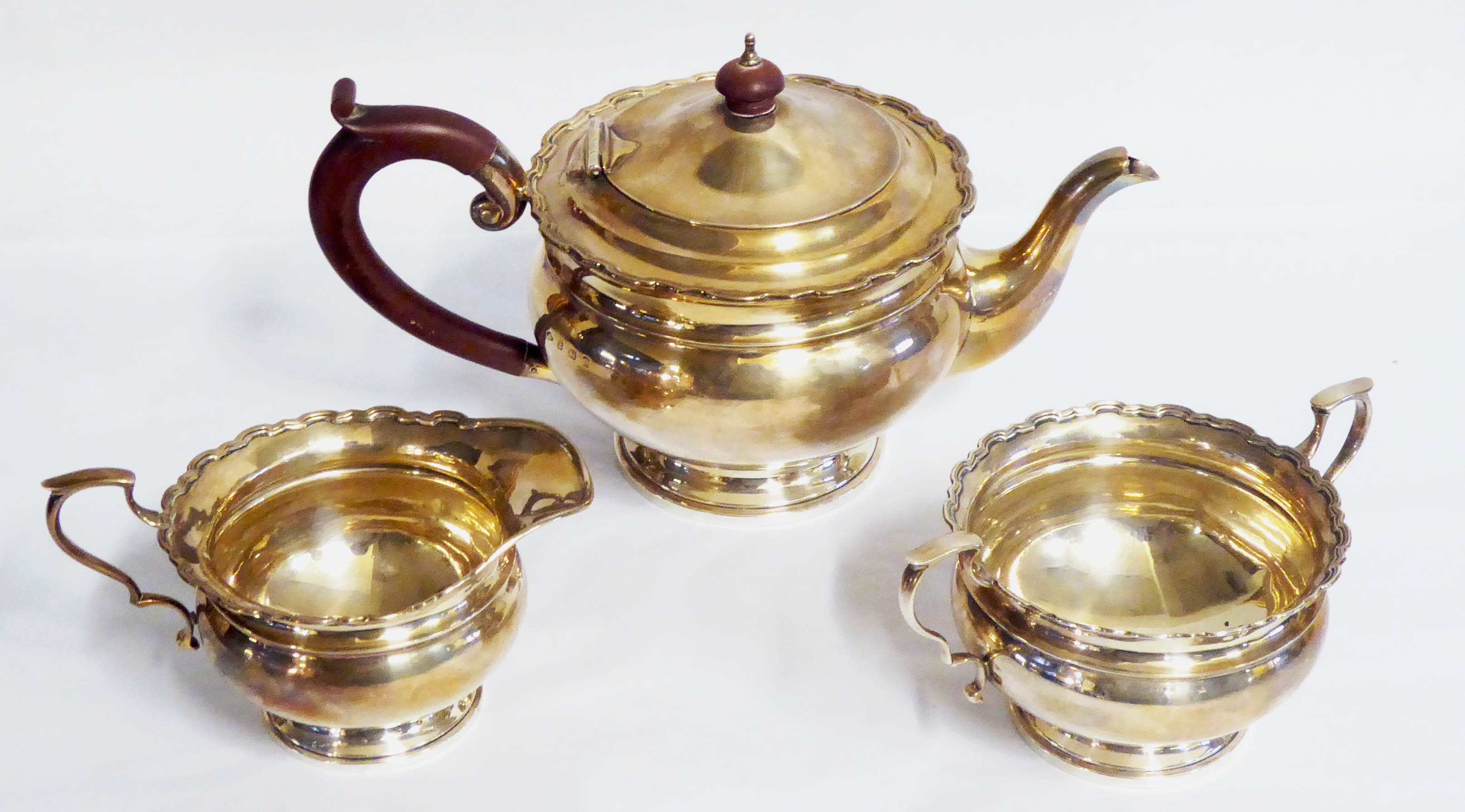 AN EDWARDIAN SILVER THREE PIECE TEA SET Comprising a teapot, cream jug and sugar basin, all with