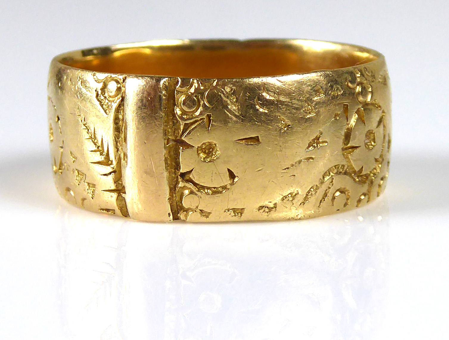 A VINTAGE 18CT GOLD WEDDING BAND Finely engraved with floral scrolls (size M).