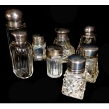 A COLLECTION OF EIGHT VICTORIAN SILVER AND CUT GLASS SCENT BOTTLES Each having circular screw caps