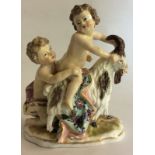 A PORCELAIN FIGURAL GROUP Classical style putti at play, wearing colourful clothes and riding a