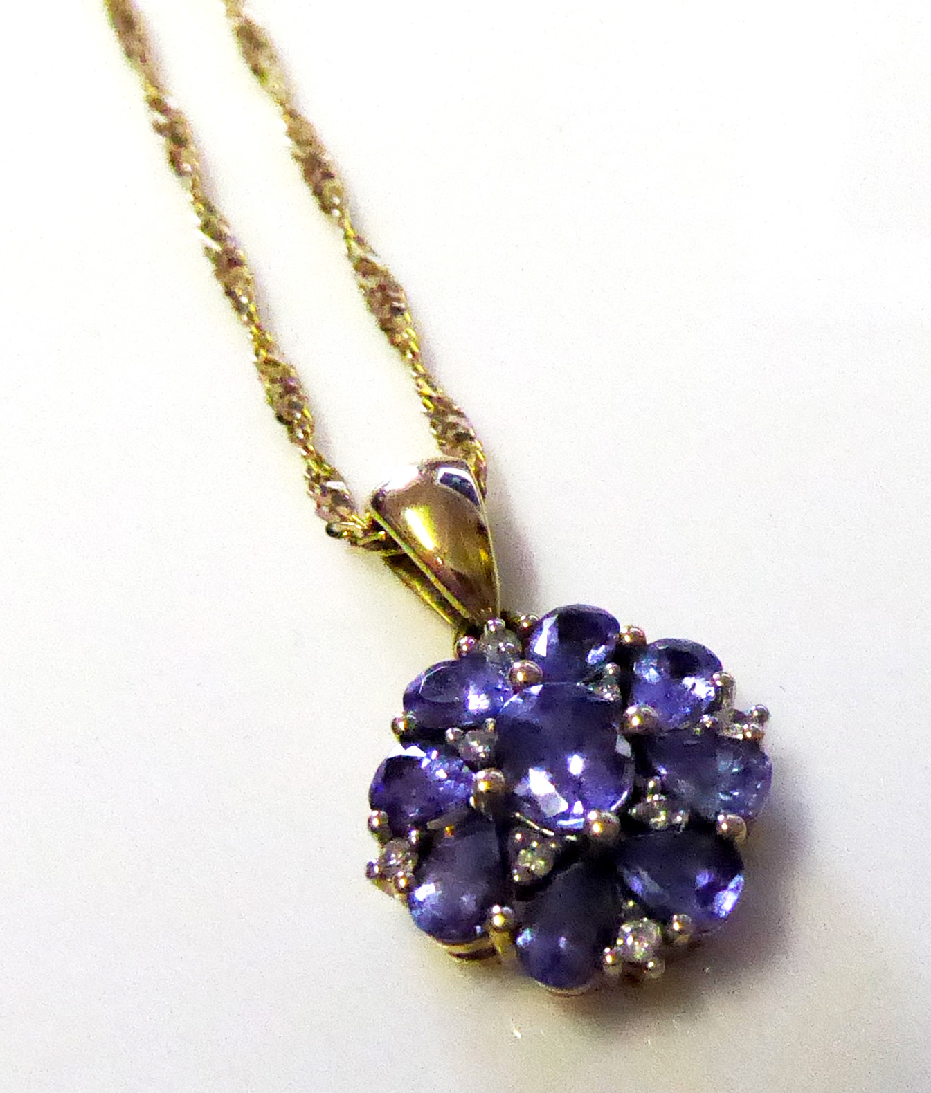 A 9CT GOLD, DIAMOND AND GEM SET DAISY CLUSTER PENDANT AND NECKLACE Set with an arrangement of blue