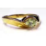 A 9CT GOLD AND PERIDOT RING Having a single pear cut stone set in a half twist mount (size O).