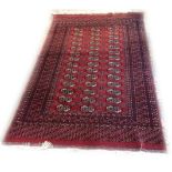 A VINTAGE BOKHARA RUG Red ground with central field containing three rows of geometric motifs. (