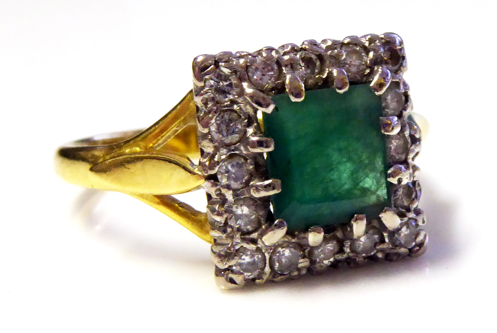 A VINTAGE 9CT GOLD, EMERALD AND DIAMOND RING Having a square cut emerald edged in diamonds (size M).