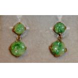 A VINTAGE PAIR OF YELLOW METAL AND JADE EARRINGS Two carved jade spherical drops, held in a plain