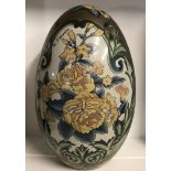 G. FIERAVINO, A VERY LARGE CHINA EGG With floral decoration on a cream and gilt ground, signed.
