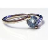 A VINTAGE 18CT WHITE GOLD AND AQUAMARINE RING Having a single round stone held in a half twist mount