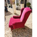 A GEORGIAN STYLE WING ARMCHAIR Upholstered in a red wine velvet, raised on cabriole legs with