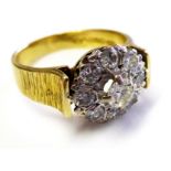 AN 18CT GOLD AND DIAMOND DAISY CLUSTER RING (size M).