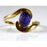 A VINTAGE YELLOW METAL AND SAPPHIRE SOLITAIRE RING Having a single oval cut stone set in a twist