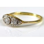 AN EARLY 20TH CENTURY THREE STONE DIAMOND RING Set with three graduating diamonds edged with smaller