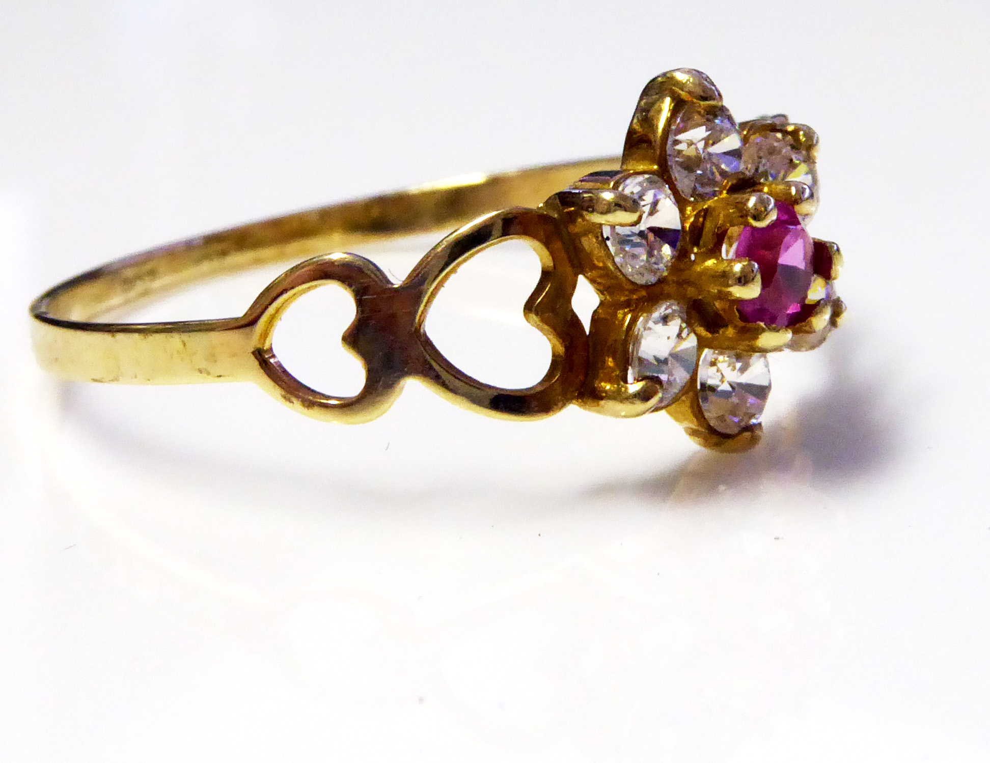 A VINTAGE 9CT GOLD, RUBY AND WHITE SAPPHIRE RING The single ruby edged with sapphires and held in