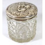AN EDWARDIAN SILVER AND CUT GLASS TRINKET JAR The lid embossed with angels on a hobnail cut glass