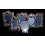 SIX 20TH CENTURY SILVER PHOTOGRAPH FRAMES To include three heart form framed with foliate repoussé