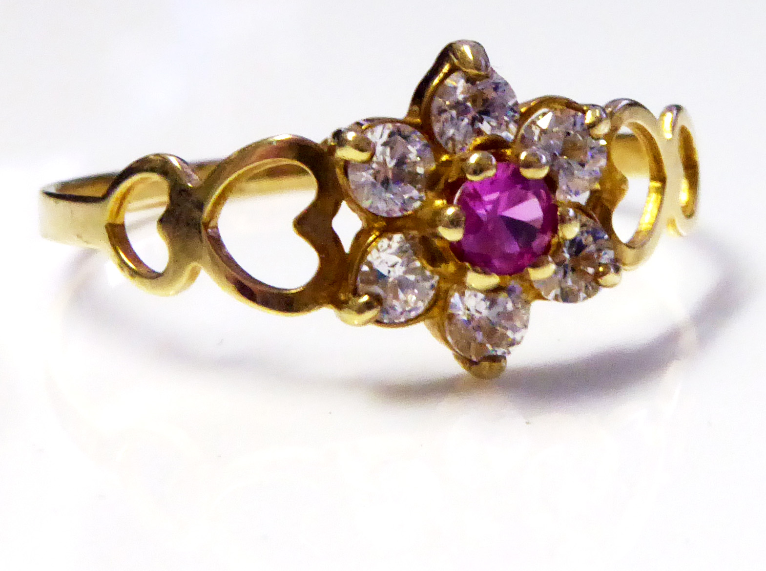 A VINTAGE 9CT GOLD, RUBY AND WHITE SAPPHIRE RING The single ruby edged with sapphires and held in - Image 2 of 2