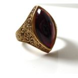 A VINTAGE 9CT GOLD AND GARNET SET SIGNET RING The cabochon cut garnet held in an engraved gold mount