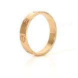 CARTIER, AN 18CT GOLD 'LOVE' RING With stamped screw motif and incised inner band 'Cartier,