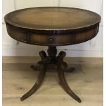 A 20TH CENTRY MAHOGANY DRUM TABLE With tooled leather top and a single drawer over a turned