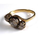 AN EARLY 20TH CENTURY YELLOW METAL AND DIAMOND THREE STONE RING The three round cut graduating