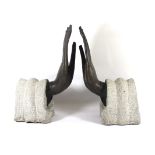 A PAIR OF 20TH CENTURY BRONZE BUDDHIST HANDS With elongated fingers, set on carved stone sleeves. (